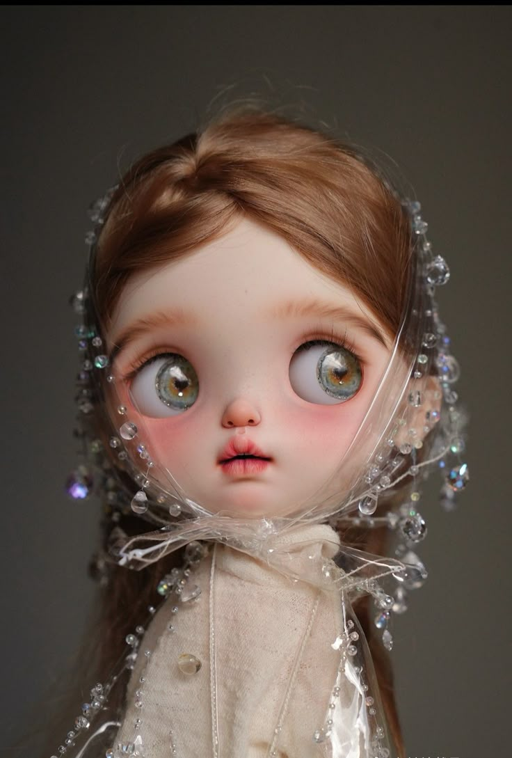 a close up of a doll wearing a dress and headdress with blue eyes