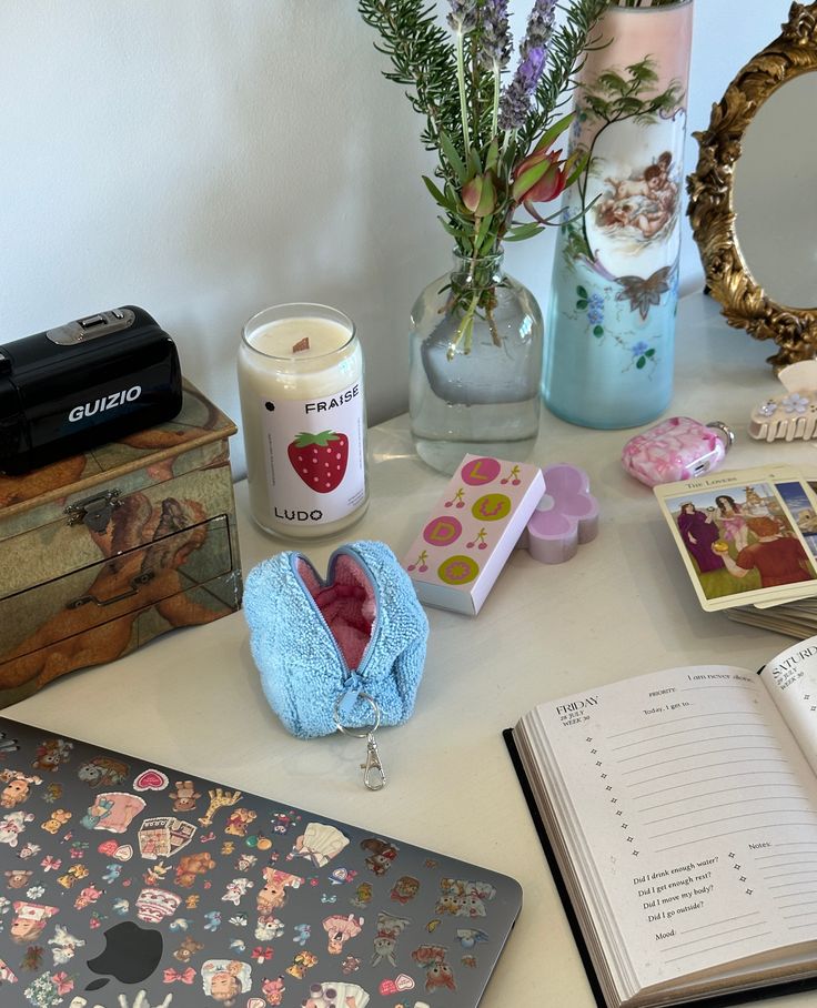 an open book sitting on top of a table next to a vase filled with flowers