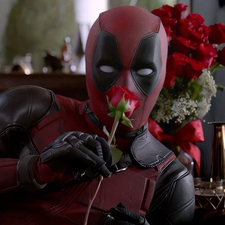 the deadpool is holding a rose in his hand