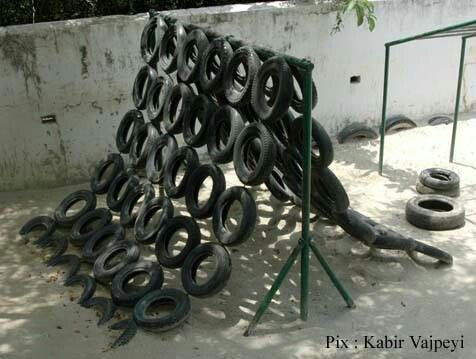 a pile of old tires sitting on top of a cement ground next to a metal rack