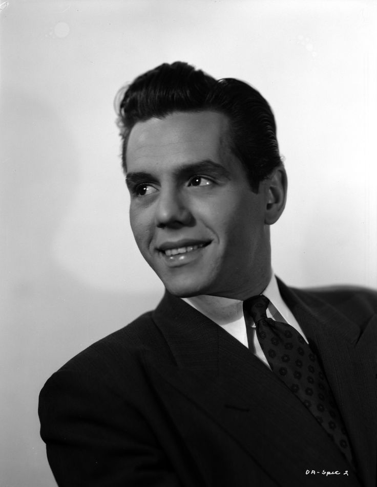 a black and white photo of a man in a suit with a smile on his face