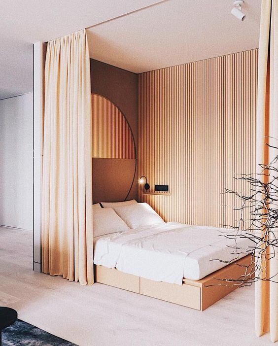 a bed sitting in a bedroom next to a tall wooden headboard on top of a hard wood floor