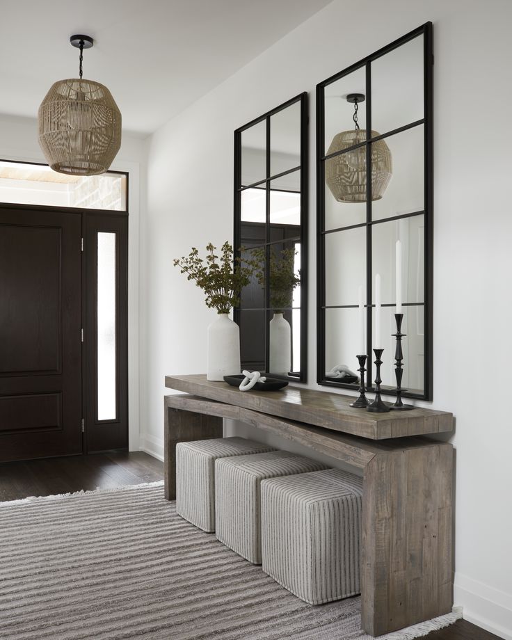 an entryway with mirrors, bench and stools on the carpeted floor in front of it