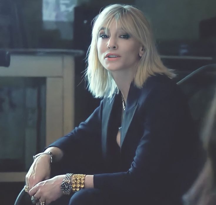 a woman with blonde hair sitting in front of a tv