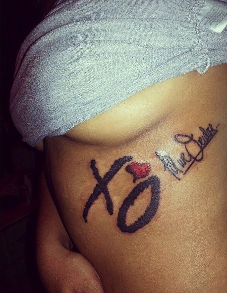 a pregnant belly with an xo tattoo on it's side and the word love written in cursive writing