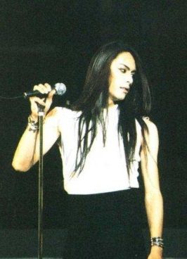 a woman with long hair holding a microphone