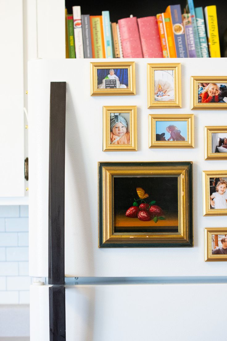 a refrigerator covered in pictures and framed photos