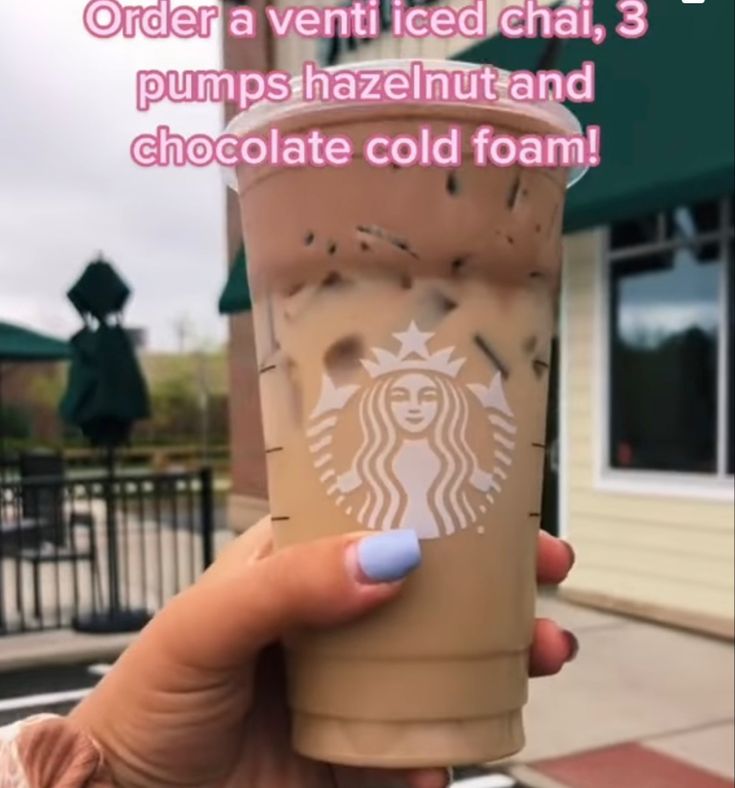 a woman holding up a cup of coffee with the caption order a ventt iced chai, 3 pumps hazelnut and chocolate cold foam