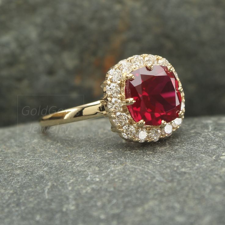 a close up of a ring with a red stone in the middle and white diamonds around it