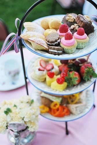 three tiered trays filled with different types of pastries on top of a table