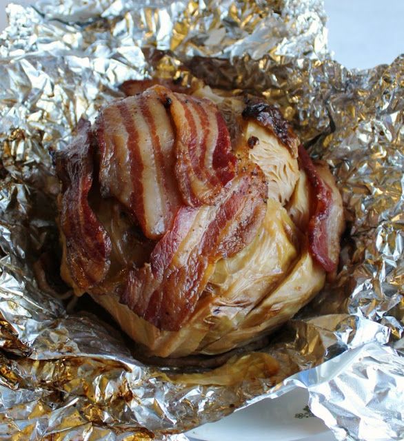 bacon wrapped in foil sitting on top of a white plate with silver foil around it