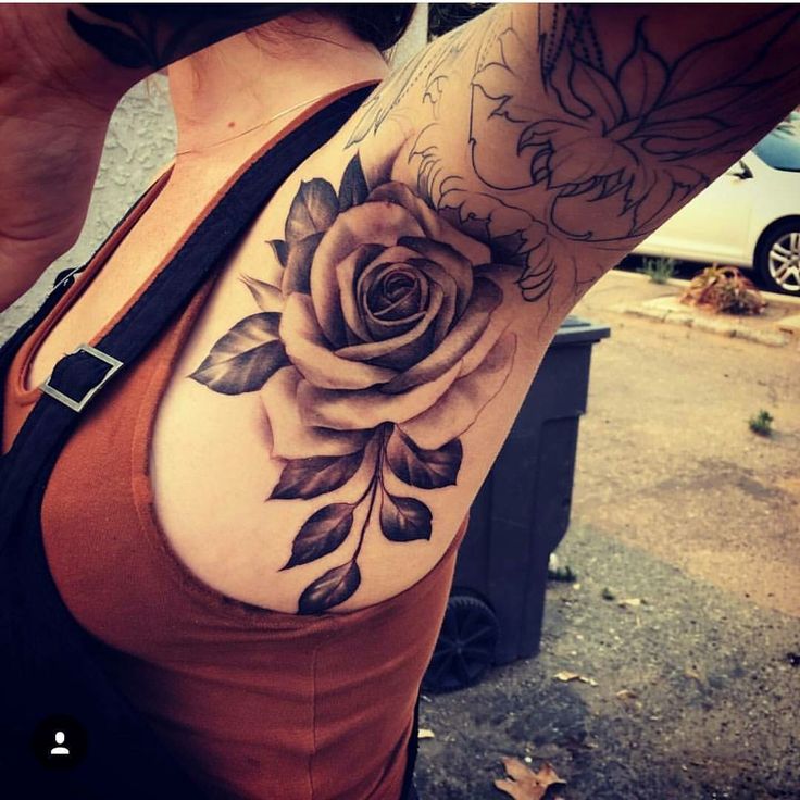 a woman's arm with a rose tattoo on the left side of her shoulder