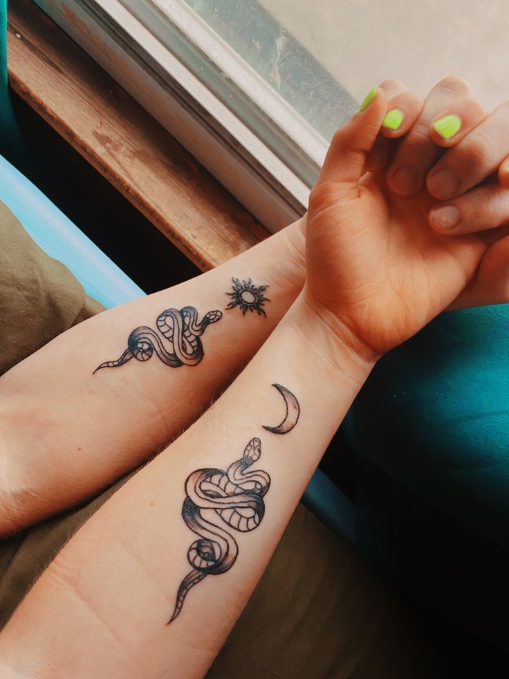 two people with matching tattoos on their arms