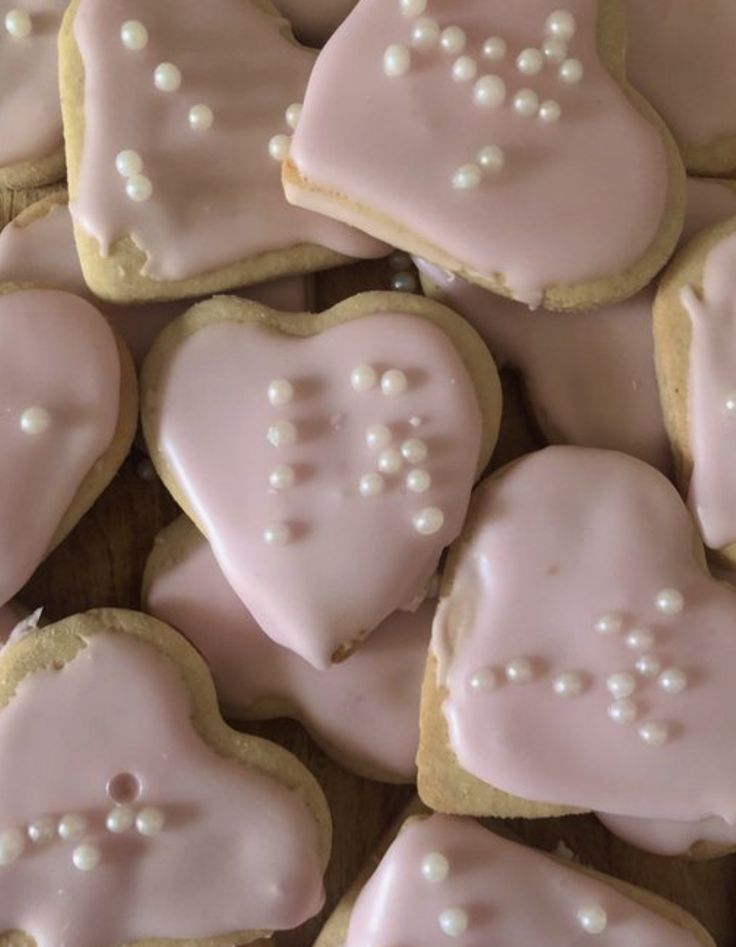 some heart shaped cookies with white frosting on them