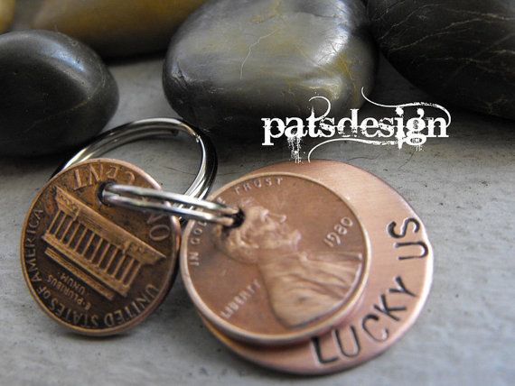 a penny keychain with the word lucky written on it next to some rocks