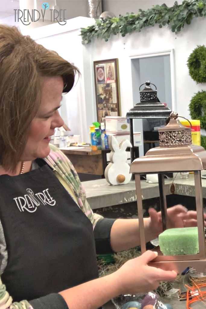 a woman holding a soap bar in front of a counter with other items on it