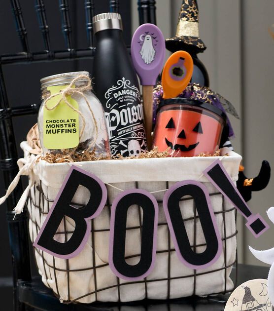 a halloween gift basket with booze, cookies, and other items in it sitting on a chair