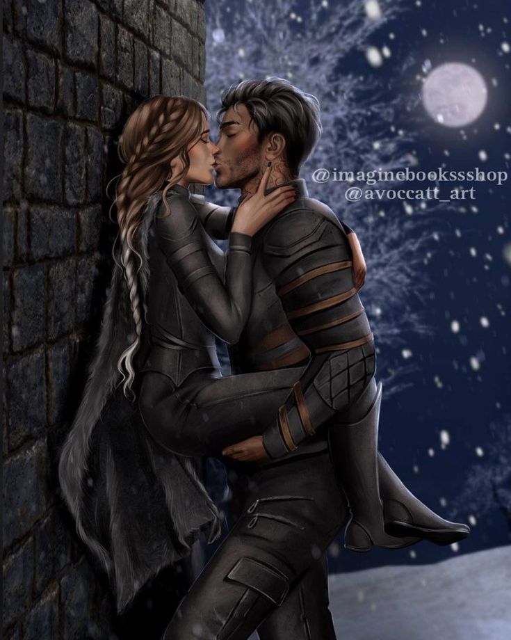 a man and woman are kissing in front of a brick wall with snow falling on the ground