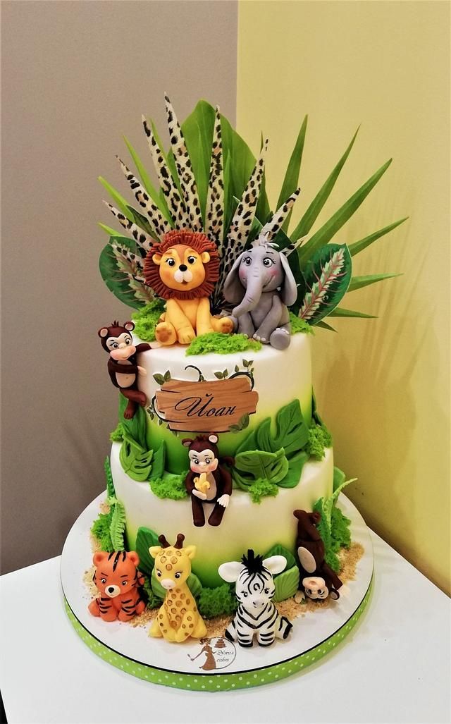 a three tiered cake decorated with animals and plants