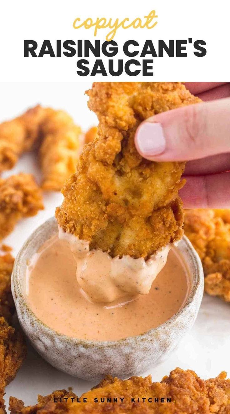 a person dipping sauce on some fried food in a small bowl with the words copycat raising cane's sauce