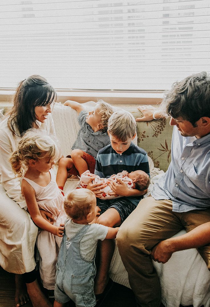 a group of people sitting on top of a couch with a baby in their lap