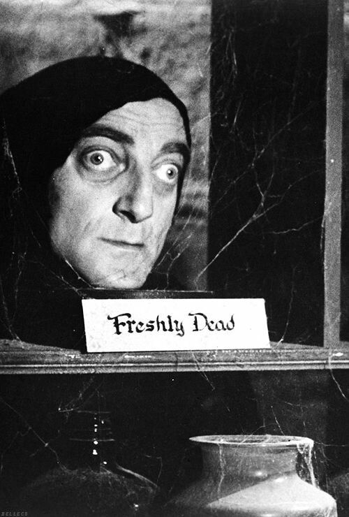 a black and white photo of a man behind a sign that says freshy bud