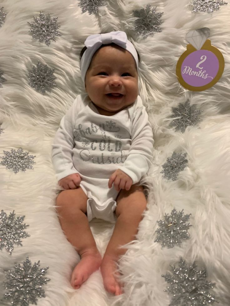 a baby sitting on top of a fluffy white blanket