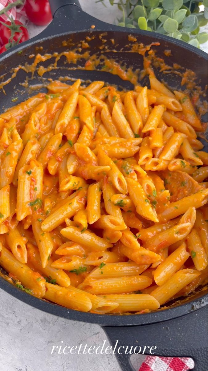 a pan filled with pasta and sauce on top of a stove