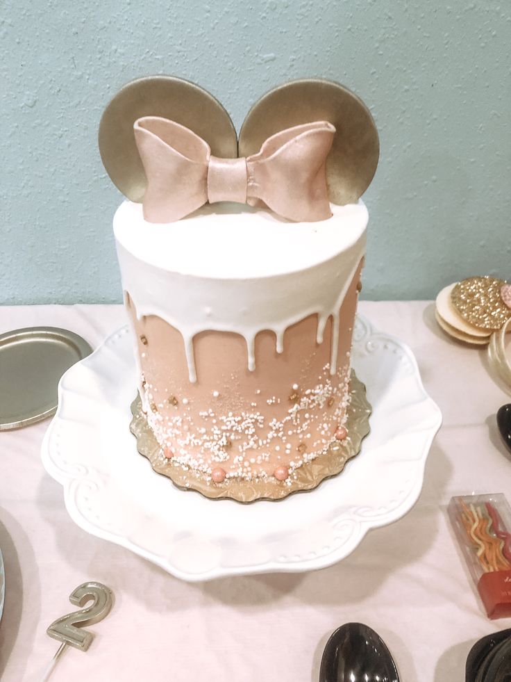 a minnie mouse cake on a table with other decorations