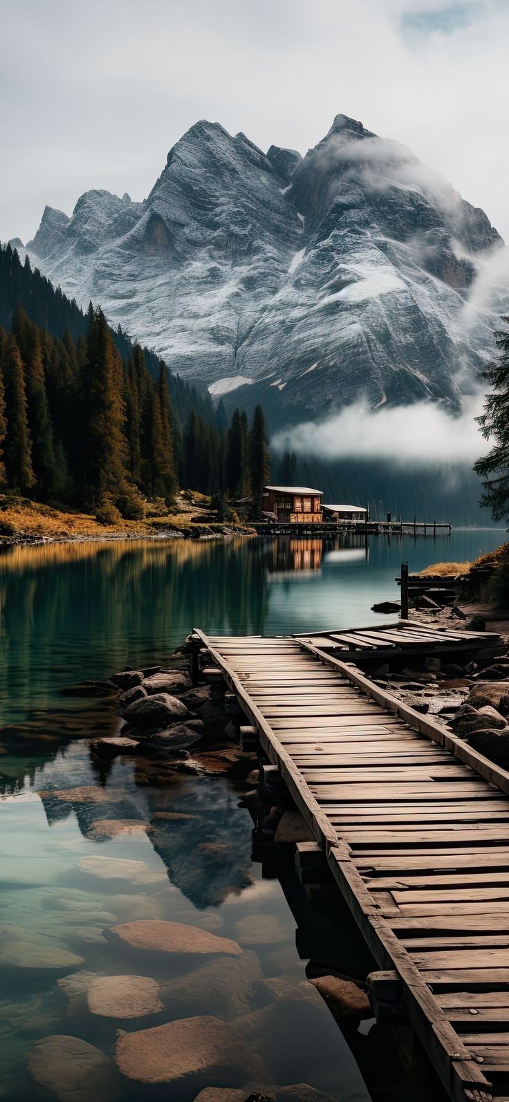 a wooden dock sitting next to a mountain lake