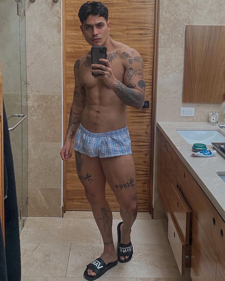 a shirtless man taking a selfie in the bathroom