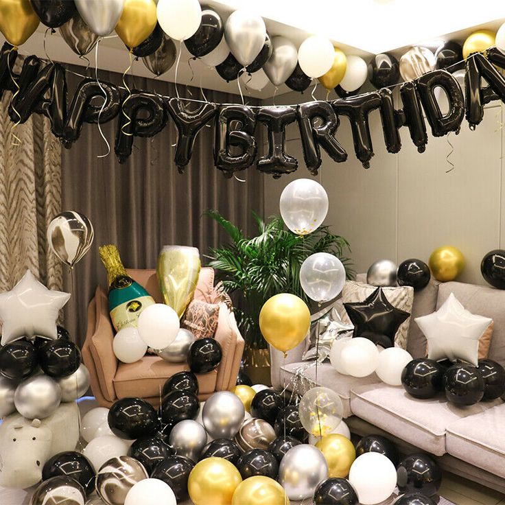 a room filled with balloons and black and white decorations for a birthday party or celebration