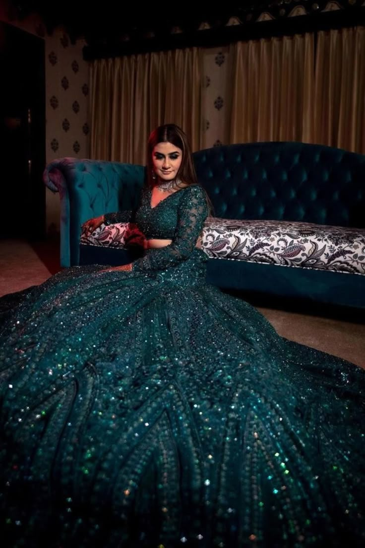 a woman sitting on a couch in a green dress