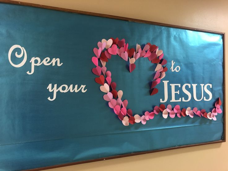 a bulletin board with paper hearts and the words open your heart to jesus on it