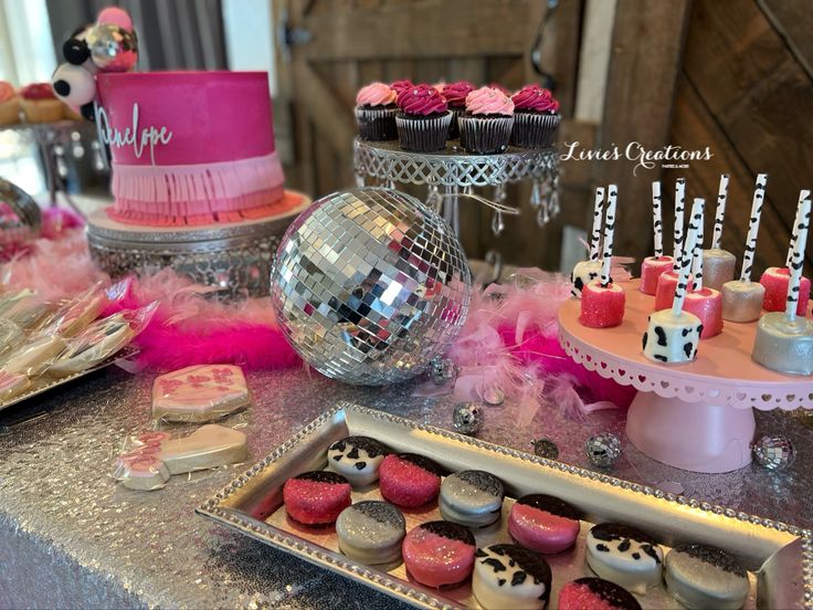 a table topped with lots of cupcakes and cakes