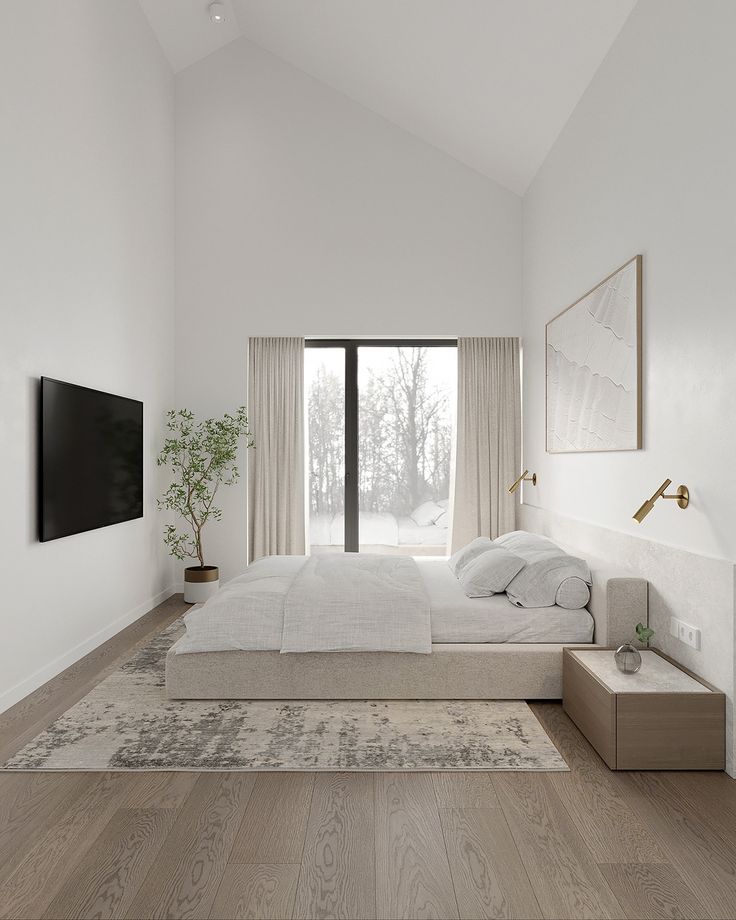 a bedroom with white walls and wood flooring has a large window overlooking the woods