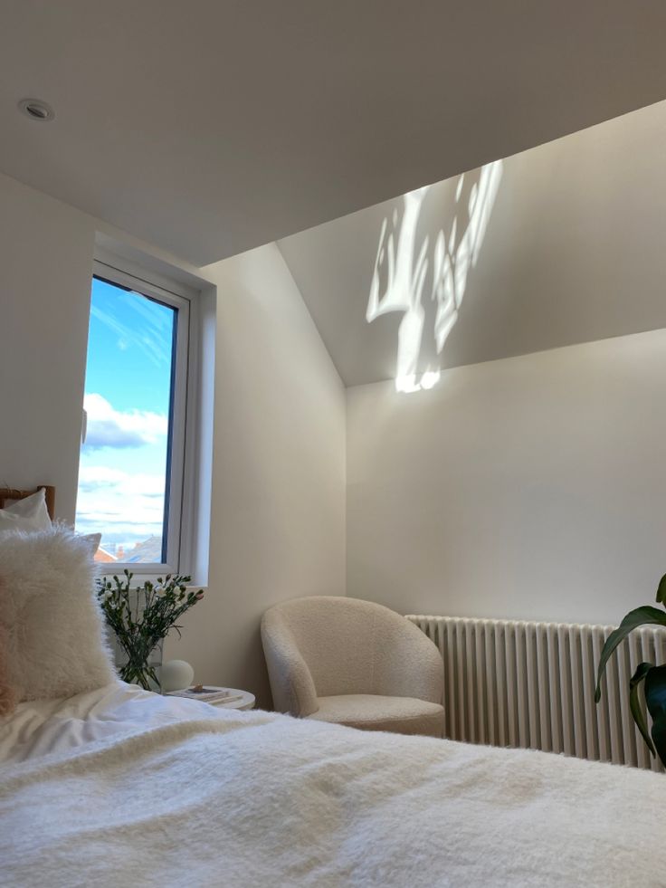 a bedroom with a bed, chair and window