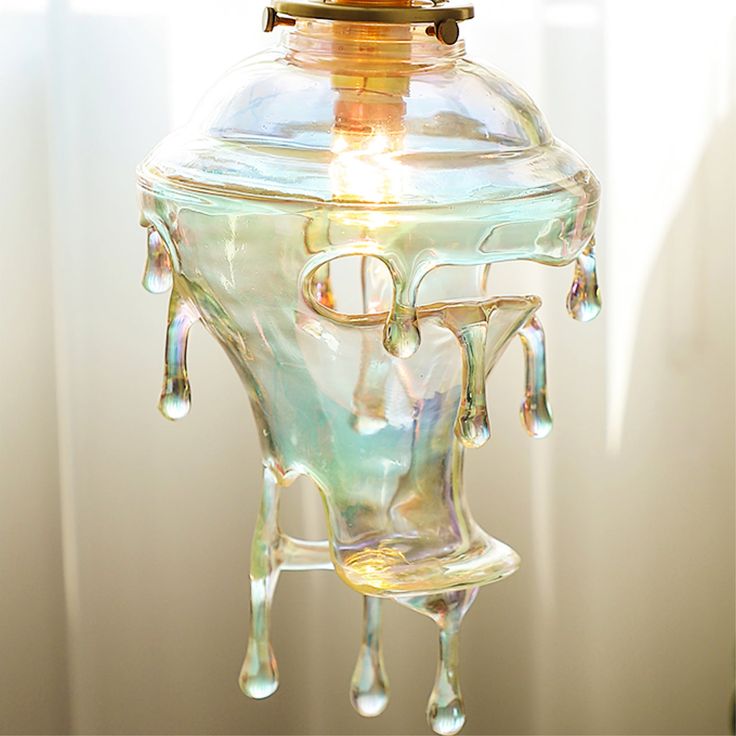 a glass light fixture with water dripping from it