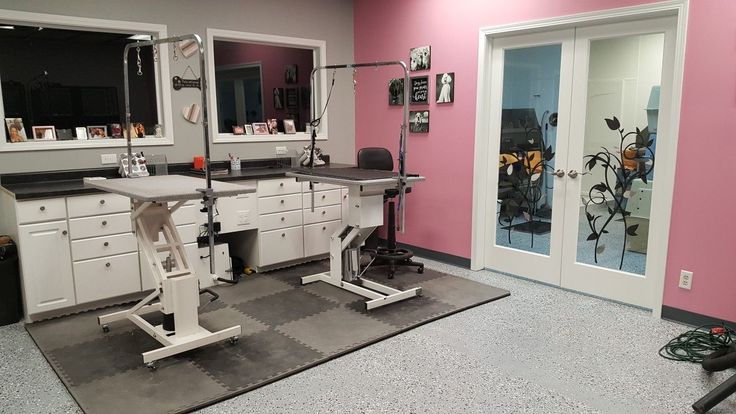 a pink and gray room with two mirrors, a table and some lights on it