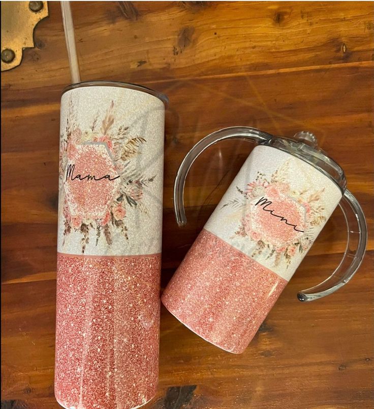 two pink and white coffee mugs sitting on top of a wooden table next to a bottle opener