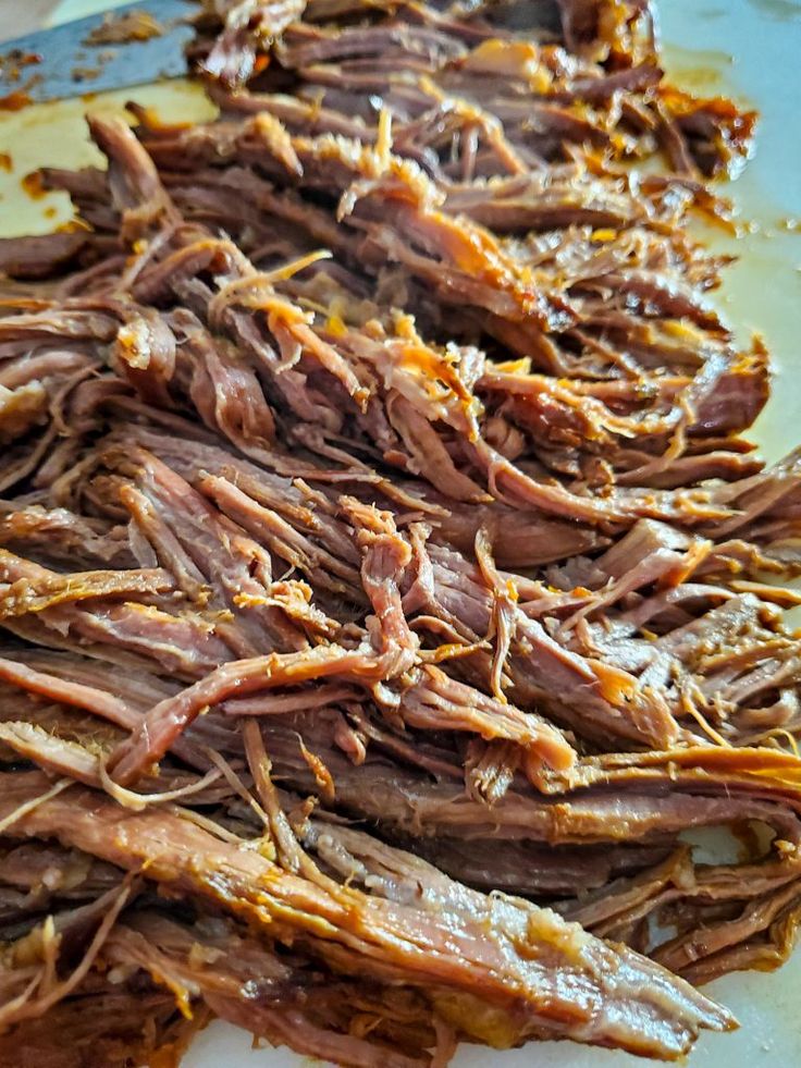 shredded meat sitting on top of a cutting board