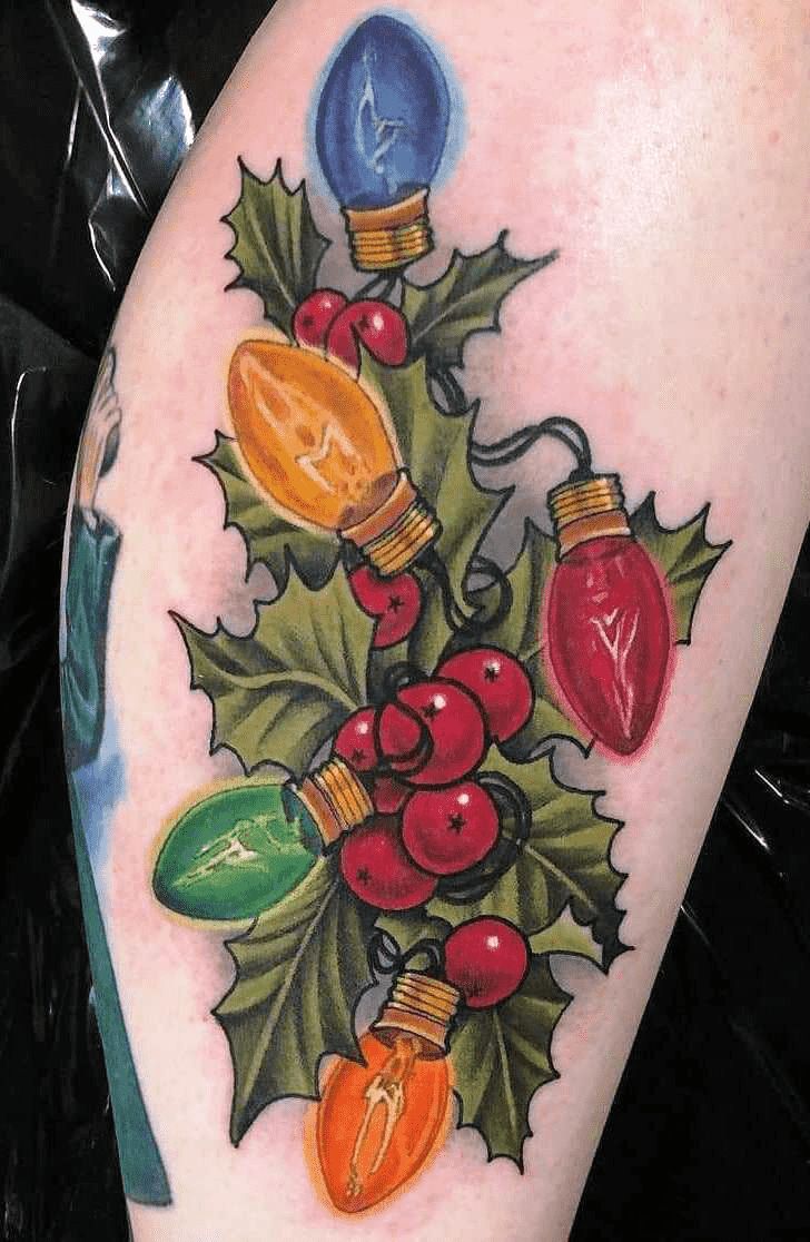 a tattoo with christmas lights and holly leaves on it