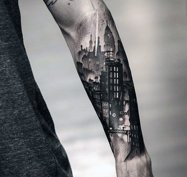 a man's arm with a city skyline tattoo on it