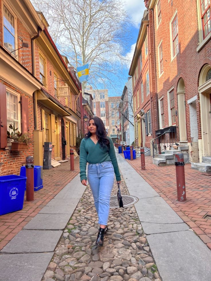 a woman is walking down the street with her hand in her pocket and looking back