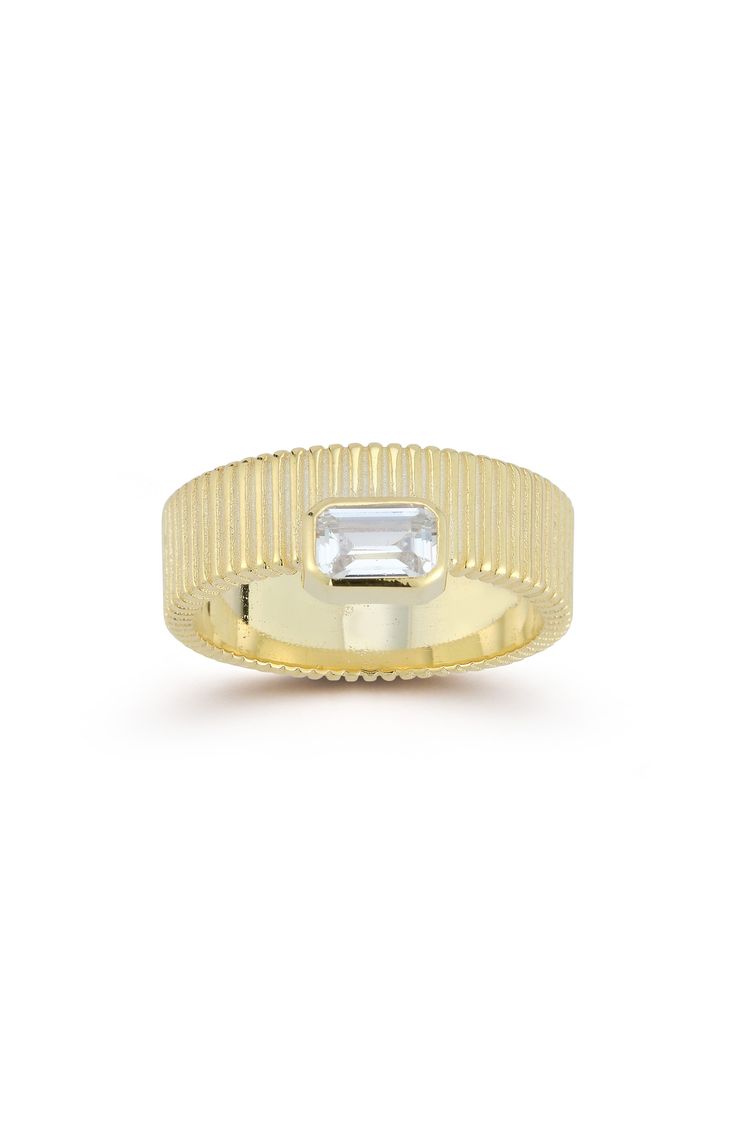 An emerald cut cubic zirconia stone is offset at the center of a fluted textured sterling silver ring that shines with a 14K yellow gold plated finish. 6.5" width 14K yellow gold plated sterling silver/cubic zirconia Imported 14k Gold Jewelry With Fluted Bezel For Gift, Timeless Jewelry With Fluted Bezel For Gifts, Diamond Jewelry With Fluted Bezel As Gift, Modern White Topaz Emerald Cut Jewelry, Modern Channel Set Emerald Cut Jewelry, Modern Emerald-cut Channel-set Jewelry, Modern Emerald Cut Channel Set Jewelry, Emerald Cut Channel Set Diamond Ring Gift, Timeless Channel Set Emerald Cut Jewelry