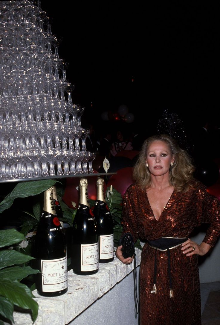 a woman standing next to bottles of wine