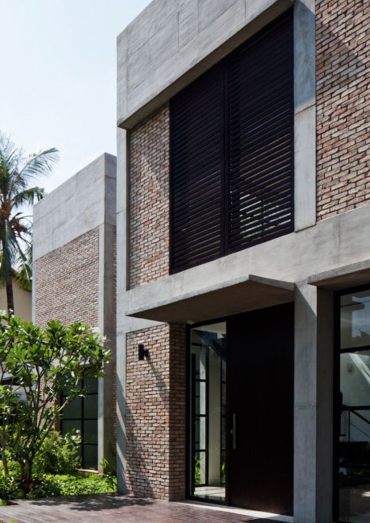 the front entrance to a modern building with large windows and shutters on both sides