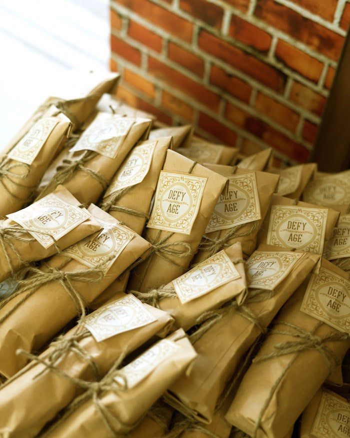 many packages tied together with twine and string on the floor next to a brick wall