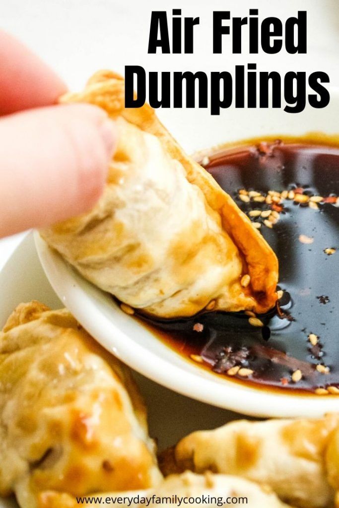 a hand dipping sauce onto some fried dumplings in a white bowl with text overlay that reads, air fried dumplings