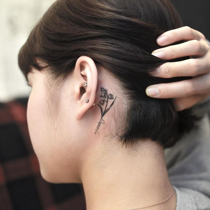 a woman with a small tattoo behind her ear